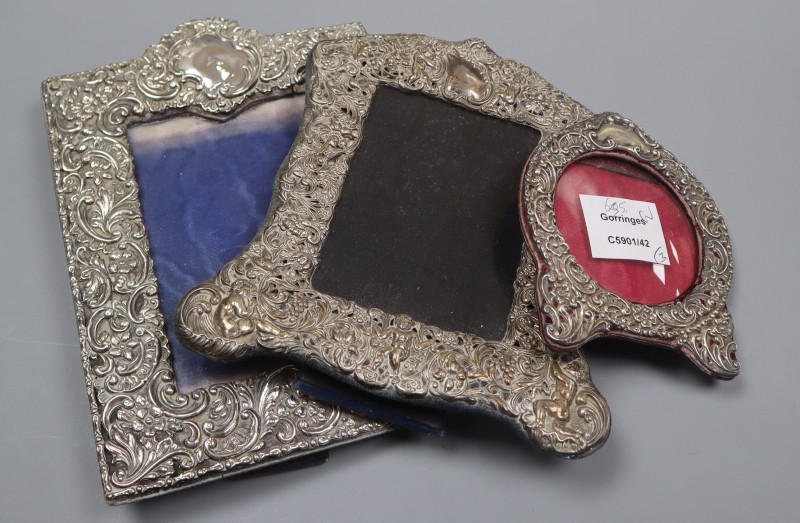Three assorted Edwardian repousse silver mounted photograph frames, largest 23.1cm.